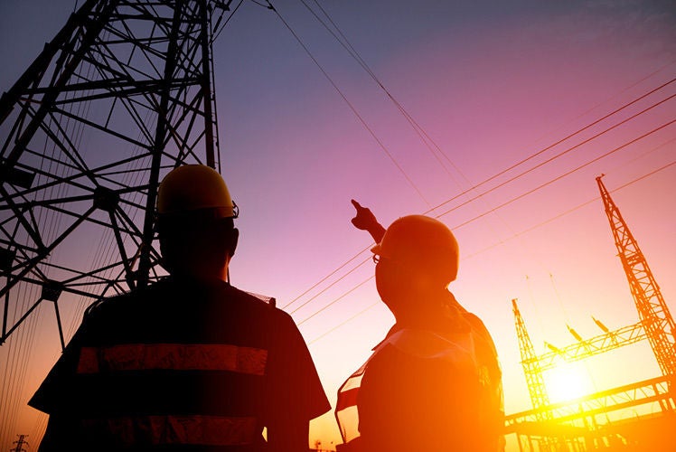 What is a surge Two electricians looking at electrical tower