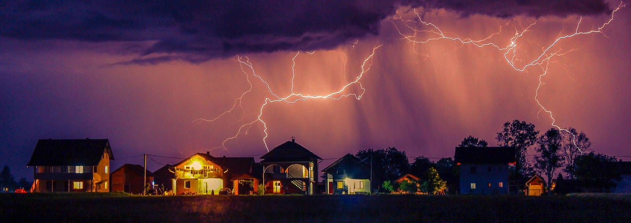 Surge Landing Page Banner Lightning storm over residential neighborhood