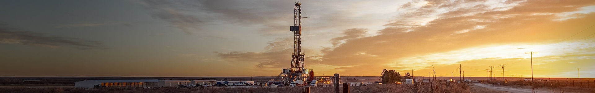 Land-based oil rig at sunset