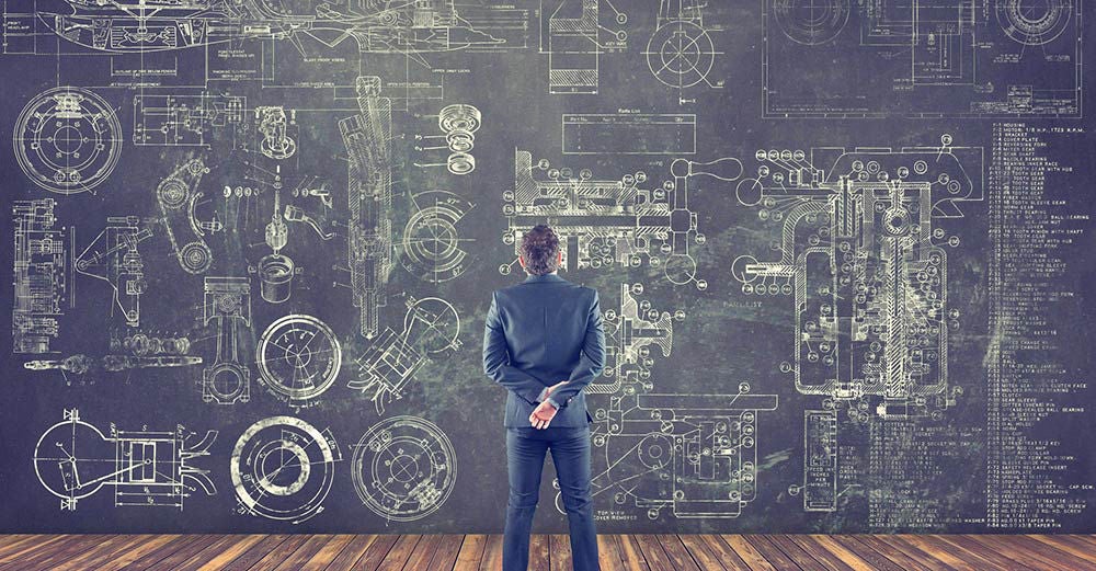 Man looking over wall of design schematics Man looking over wall of design schematics